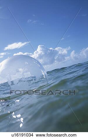 Picture - Globe beach ball floating on water. Fotosearch
