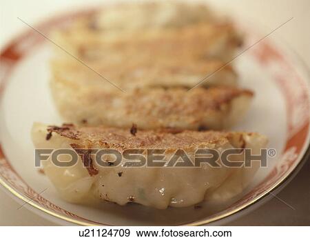 Gyoza, fried Chinese-style dumplings, served on a plate View Large Photo Image Stock Photo - Gyoza, fried Chinese-style dumplings, served on a plate. Fotosearch