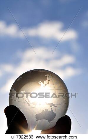 Stock Image - Hand holding globe, close up, differential focus, Hayama town, Kanagawa prefecture, Japan. Fotosearch