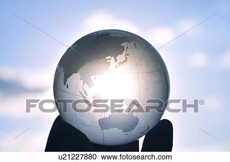 Stock Image - Hand holding globe, close up, differential focus, Hayama town, Kanagawa prefecture, Japan. Fotosearch