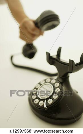 Stock Photo - Hand holding telephone receiver, white background. Fotosearch