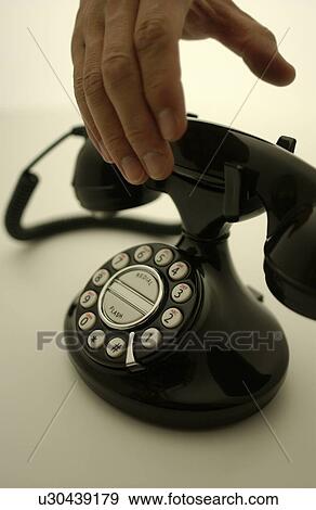 Stock Photo - Hand reaching to telephone receiver, white background. Fotosearch