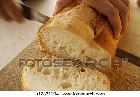 Picture - Hand slicing bread. Fotosearch