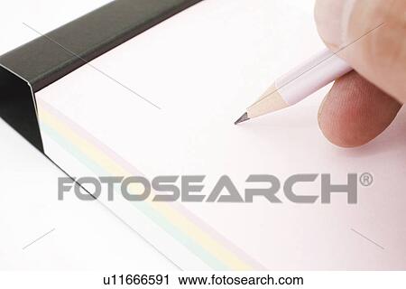 Stock Image - Hand writing on note pad, close up, white background. Fotosearch