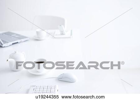 Stock Photography - Laptop and cups of coffee on desk in office. Fotosearch