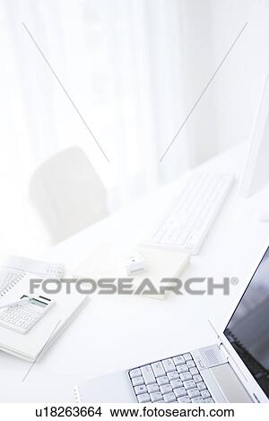 Picture - Laptop and office supplies on desk in office. Fotosearch