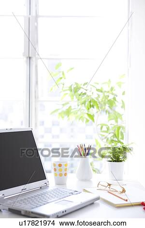 Picture - Laptop and office supplies on desk. Fotosearch