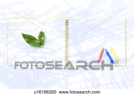 Stock Image - Leaves and crayons on sketchbook, white background. Fotosearch