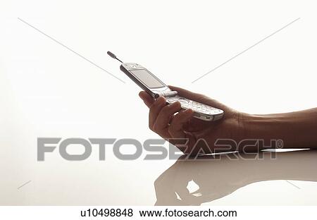 Stock Photo - Man holding mobile phone, white background. Fotosearch