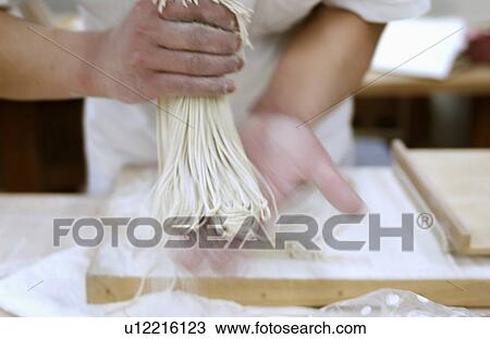 Stock Image - Man making Soba noodles, blurred motion. Fotosearch