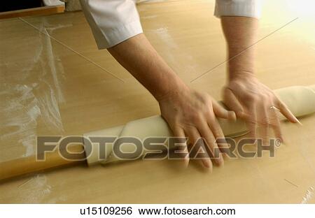 Stock Photograph - Man making Soba noodles, rolling dough, blurred motion. Fotosearch