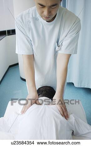 Massage therapist massaging man's back View Large Photo Image Picture - Massage therapist massaging man's back. Fotosearch
