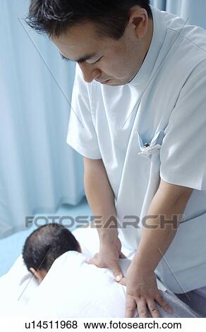 Stock Photo - Massage therapist massaging man's back. Fotosearch
