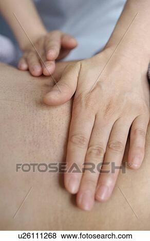 Stock Photo - Massage therapist massaging man's back, close up. Fotosearch