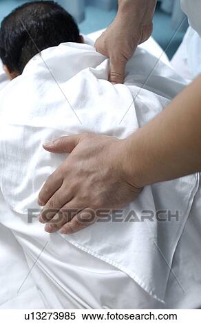 Massage therapist massaging man's back View Large Photo Image Stock Photography - Massage therapist massaging man's back. Fotosearch