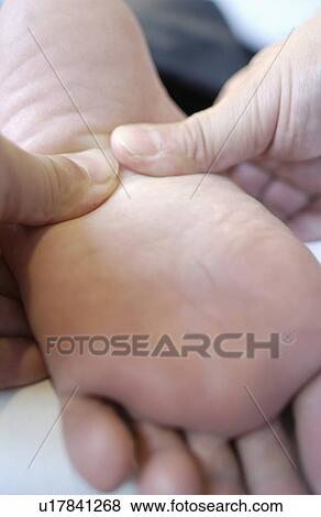Stock Photo - Massage therapist massaging man's foot, close up. Fotosearch