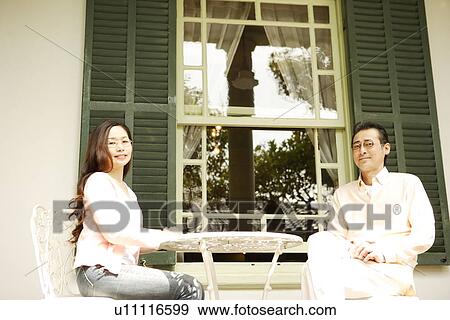 Stock Photo - Mature couple relaxing at backyard. Fotosearch
