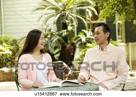 Stock Photo - Mature couple relaxing at backyard. Fotosearch