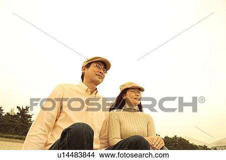 Mature couple sitting side by side View Large Photo Image Picture - Mature couple sitting side by side. Fotosearch