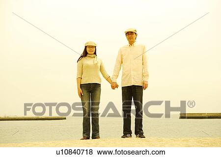 Mature couple standing on beach View Large Photo Image Stock Photo - Mature couple standing on beach. Fotosearch