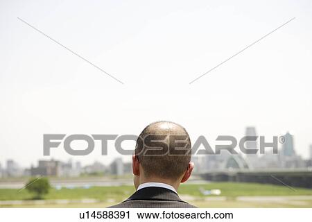 Stock Image - Mature man in empty lot, copy space. Fotosearch