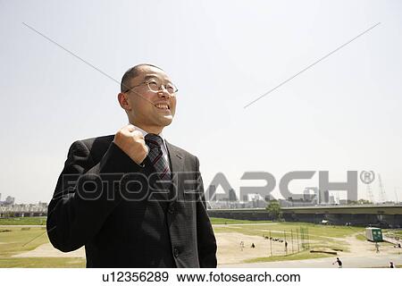 Stock Photo - Mature man standing in empty lot, smiling. Fotosearch