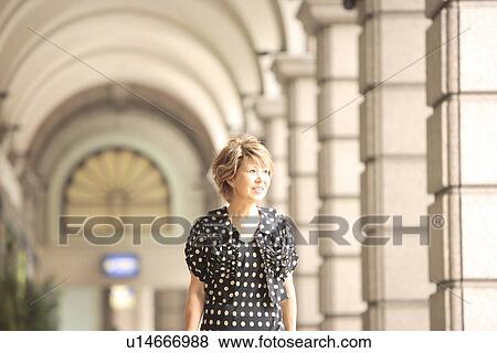 Mature woman in arcade, smiling and looking away View Large Photo Image Stock Photo - Mature woman in arcade, smiling and looking away. Fotosearch