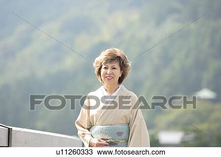 Stock Image - Mature woman in Kimono smiling, Kyoto city, Kyoto prefecture, Japan. Fotosearch