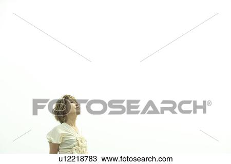 Stock Image - Mature woman looking up to sky, copy space. Fotosearch