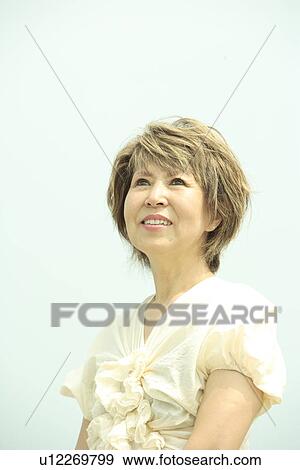 Mature woman smiling, blue background View Large Photo Image Stock Photo - Mature woman smiling, blue background. Fotosearch