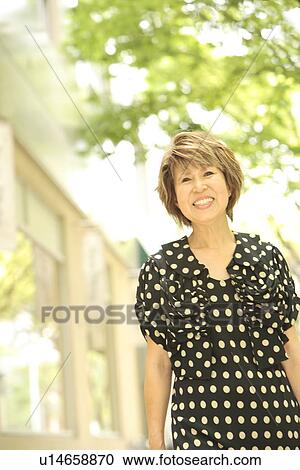 Mature woman walking down the street, smiling, differential focus View Large Photo Image Stock Image - Mature woman walking down the street, smiling, differential focus. Fotosearch