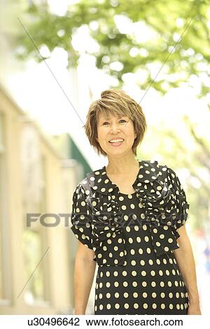 Mature woman walking down the street, smiling, differential focus View Large Photo Image Stock Image - Mature woman walking down the street, smiling, differential focus. Fotosearch