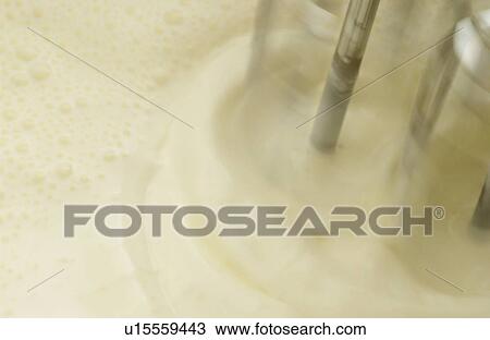 Stock Image - Mixer whipping cream, close up, blurred motion. Fotosearch