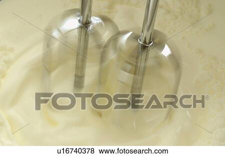 Stock Photo - Mixer whipping cream, close up, blurred motion. Fotosearch