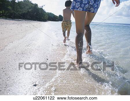 Mother and son running on beach View Large Photo Image Stock Image - Mother and son running on beach. Fotosearch