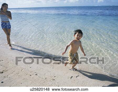 Mother and son running on beach View Large Photo Image Stock Photo - Mother and son running on beach. Fotosearch