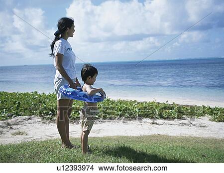 Mother and son standing on beach View Large Photo Image Picture - Mother and son standing on beach. Fotosearch