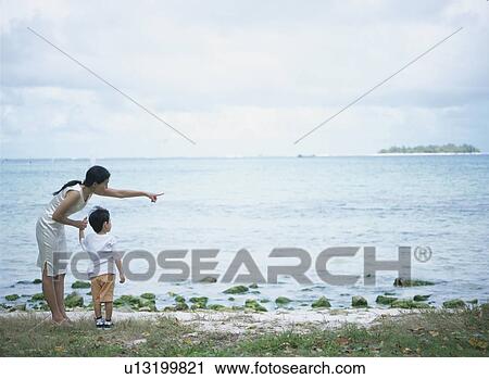 Mother and son standing on beach View Large Photo Image Stock Image - Mother and son standing on beach. Fotosearch