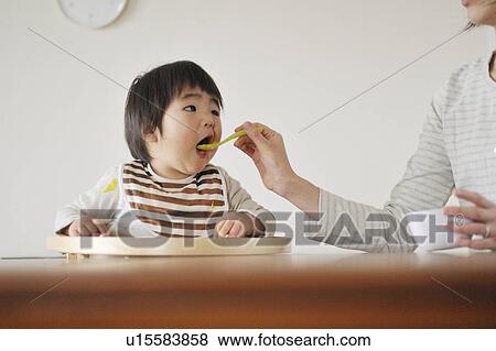 Mother feeding baby boy View Large Photo Image Stock Photo - Mother feeding baby boy. Fotosearch