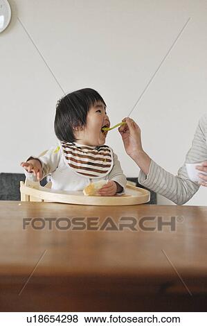 Stock Photo - Mother feeding baby boy. Fotosearch