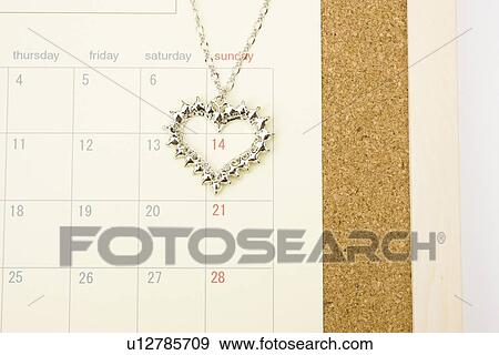 Necklace with heart pendant on calendar, close up View Large Photo Image Stock Photo - Necklace with heart pendant on calendar, close up. Fotosearch
