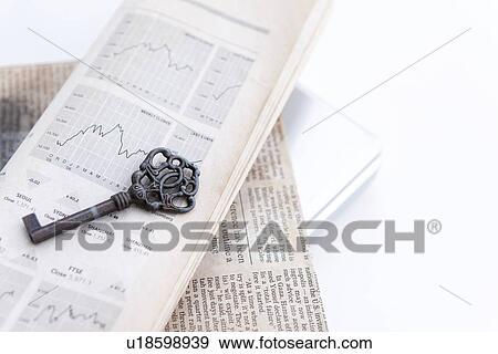 Stock Photo - Old key on newspaper, close up, white background. Fotosearch
