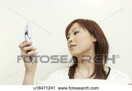 Stock Image - One young woman text messaging. Fotosearch