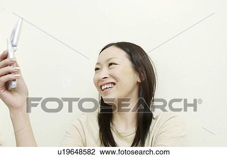 Stock Image - One young woman text messaging. Fotosearch