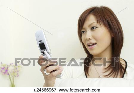 Stock Photo - One young woman text messaging. Fotosearch