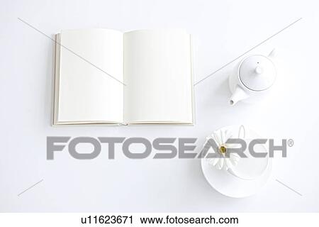 Stock Image - Opened book and coffee setting, white background. Fotosearch