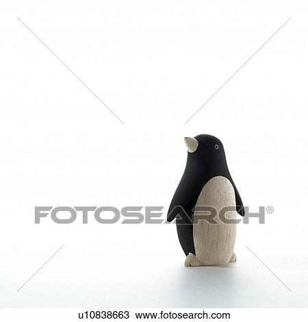 Stock Image - Penguin figurine on white background, copy space. Fotosearch