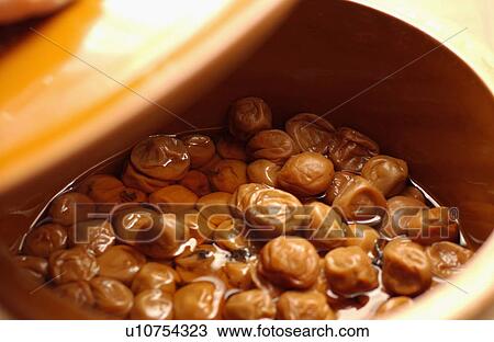 Stock Image - Pickled plums in a jar. Fotosearch