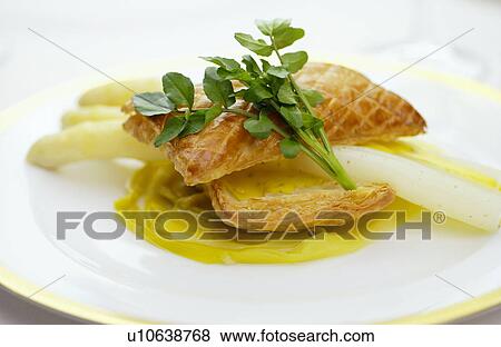 Stock Photo - Plate of asparagus and puff pastry, close up. Fotosearch