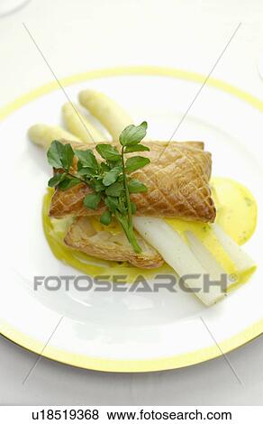 Stock Photo - Plate of asparagus and puff pastry, white background. Fotosearch